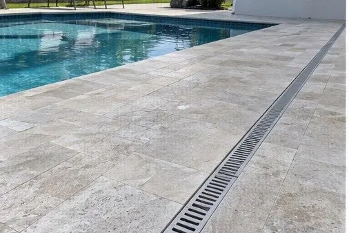 Completed stone pool deck with linear drainage