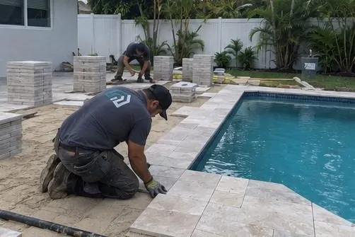 Hollywood Outdoor crew installing pavers around a residential pool