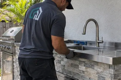 Contractor installing a stainless steel outdoor kitchen counter